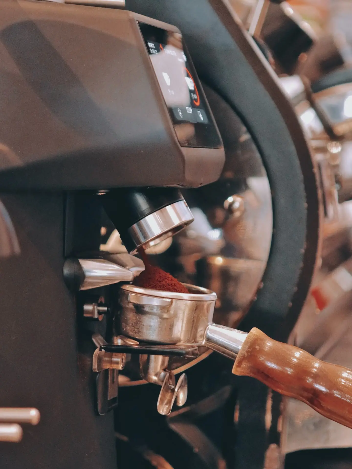 Κοντινό στη μηχανή espresso, με φρεσκοαλεσμένο καφέ μέσα στο φίλτρο.